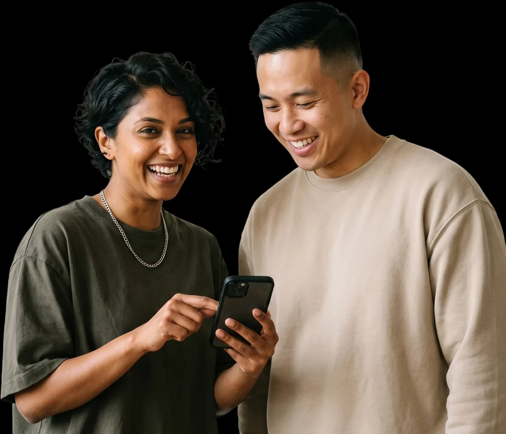 Two smiling students looking at a phone together